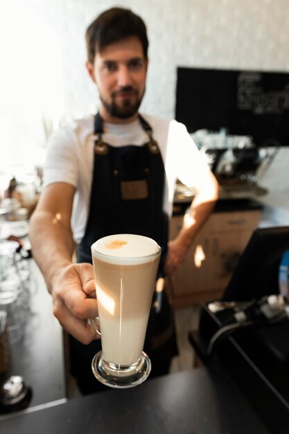 Coup moyen barista tenant une tasse de café