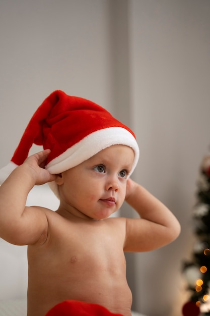 Photo gratuite coup moyen bébé portant un bonnet de noel