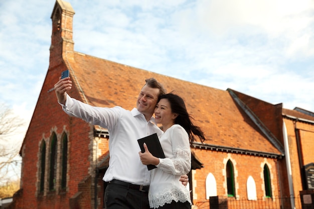 Coup moyen couple chrétien prenant selfie