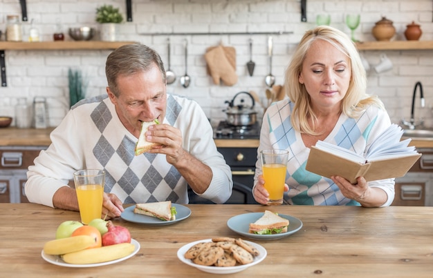 Coup moyen couple dans la cuisine avec livre