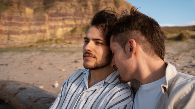 Photo gratuite coup moyen couple gay à la plage