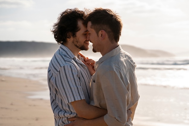 Photo gratuite coup moyen couple gay à la plage