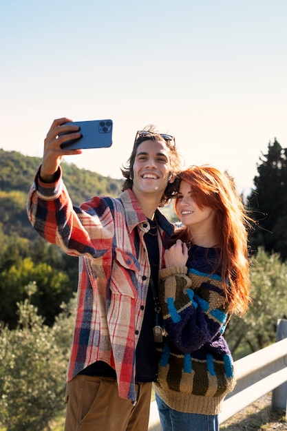 Coup moyen couple heureux prenant selfie