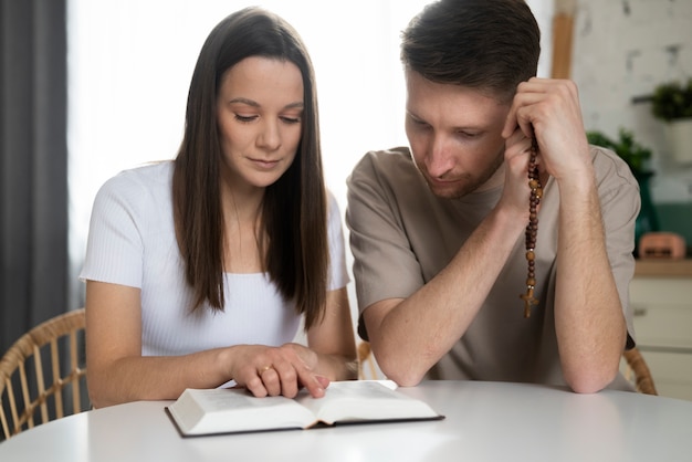 Coup moyen couple lisant la bible ensemble