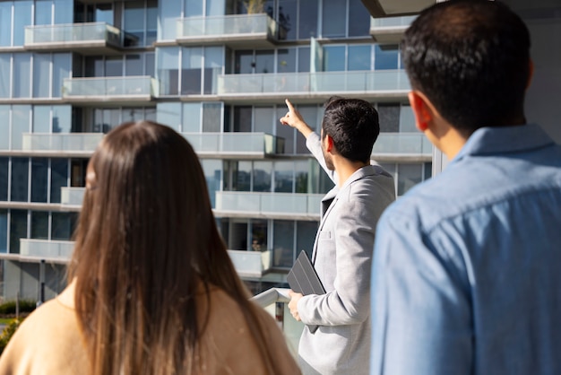 Coup moyen couple parlant à un agent immobilier