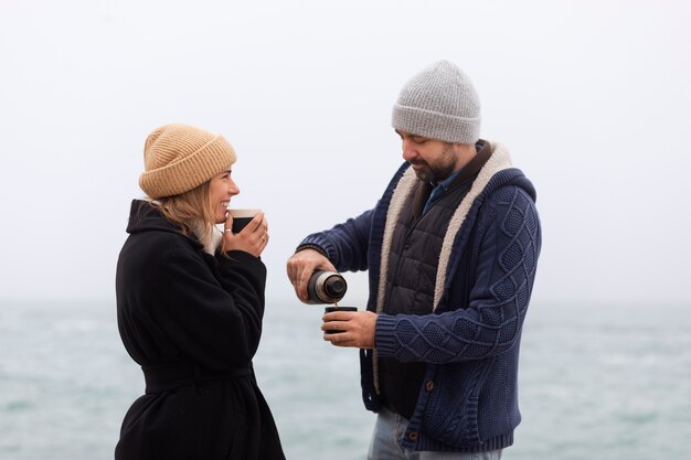 Coup moyen couple passant du temps au bord de la mer