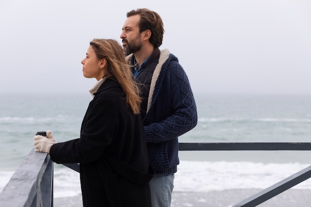 Coup moyen couple passant du temps au bord de la mer