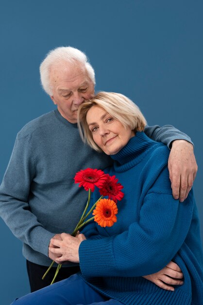 Coup moyen couple de personnes âgées avec des fleurs