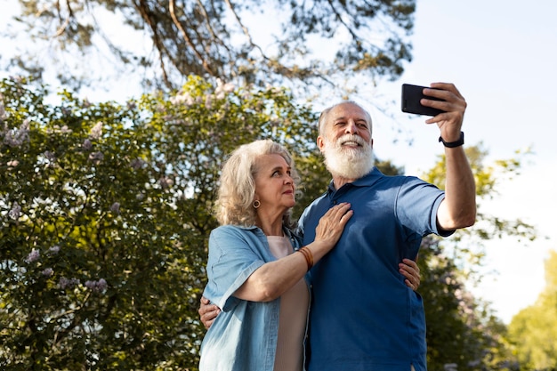 Coup moyen couple de personnes âgées prenant selfie avec téléphone