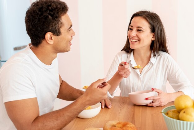 Coup moyen couple prenant son petit déjeuner dans la cuisine