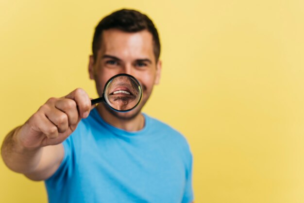 Coup moyen couvrant sa bouche avec une loupe