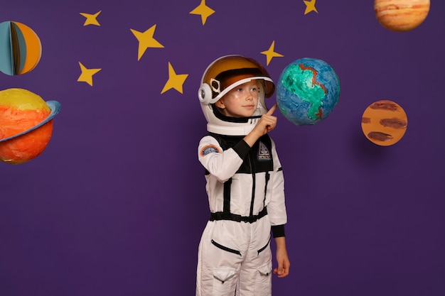Photo gratuite coup moyen enfant portant une combinaison spatiale