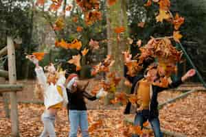 Photo gratuite coup moyen d'enfants jouant avec des feuilles