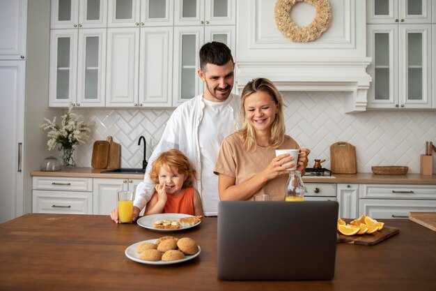 Coup moyen famille heureuse dans la cuisine