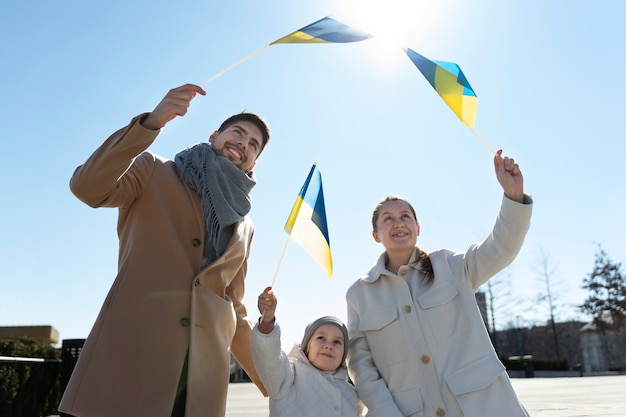 Coup moyen famille heureuse avec des drapeaux ukrainiens