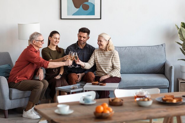 Coup moyen de la famille heureuse tinter les verres