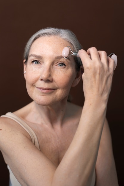 Coup moyen femme âgée massant le visage