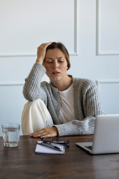 Coup moyen femme anxieuse assise au bureau