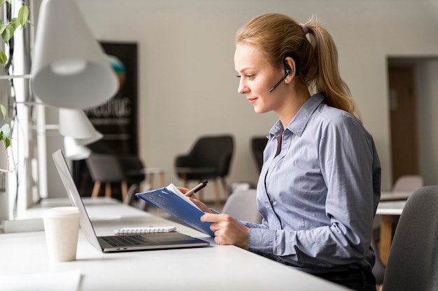 Coup Moyen Femme Assise Au Bureau