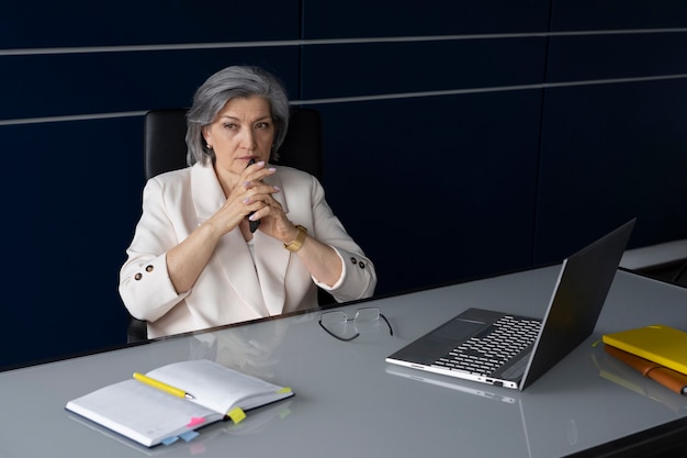 Coup moyen femme assise au bureau