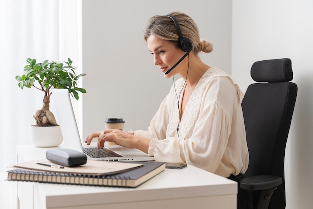 Coup moyen femme assise sur le bureau