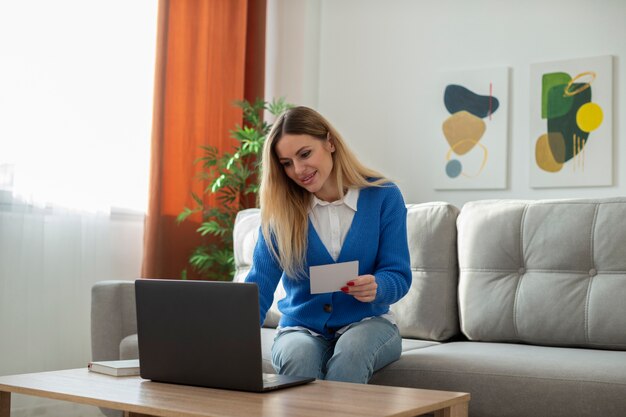 Coup moyen femme assise sur un canapé