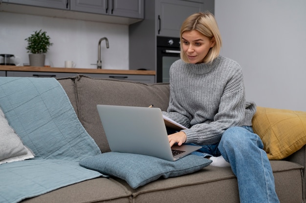 Coup moyen femme assise sur un canapé