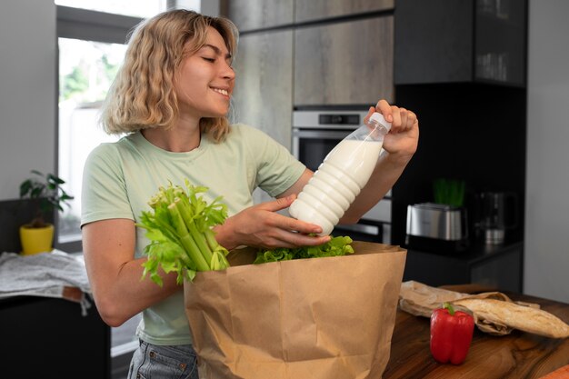 Coup moyen femme avec une bouteille de lait