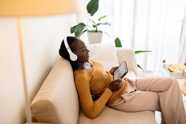 Coup moyen femme sur canapé avec tablette