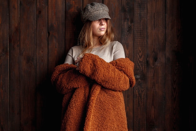 Photo gratuite coup moyen femme avec chapeau et manteau à l'intérieur