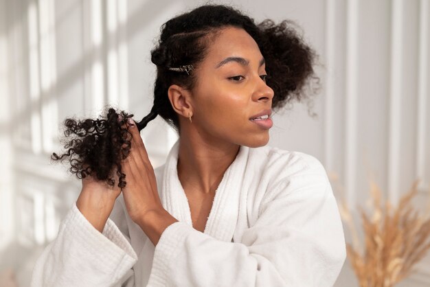 Coup moyen femme coiffant ses cheveux