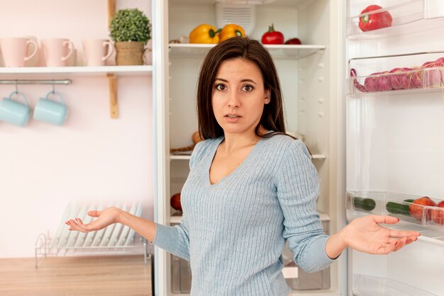 Coup moyen femme confuse dans la cuisine