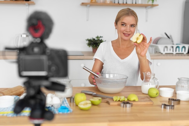 Coup moyen femme cuisinant avec des pommes