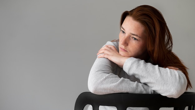 Photo gratuite coup moyen femme déprimée assise sur une chaise