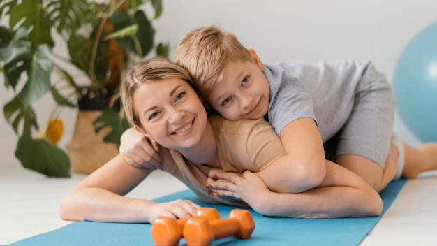 Coup moyen femme et enfant sur tapis de yoga