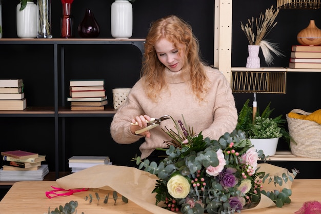 Coup moyen femme faisant un bouquet de fleurs