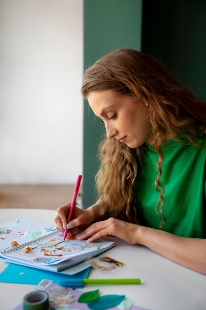 Coup moyen femme faisant un journal créatif