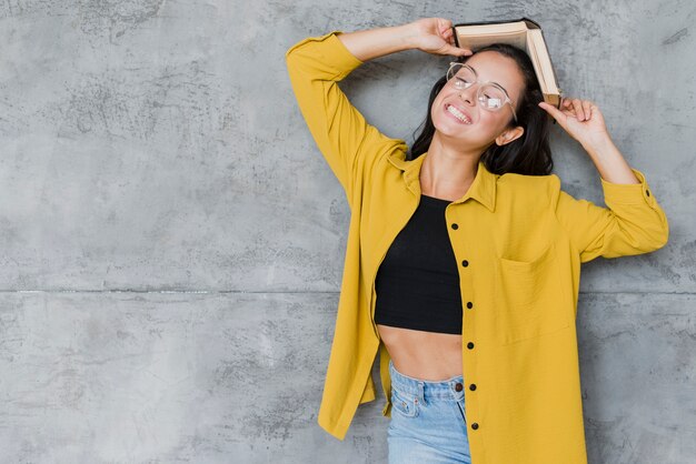 Coup moyen femme avec fond de livre et de ciment