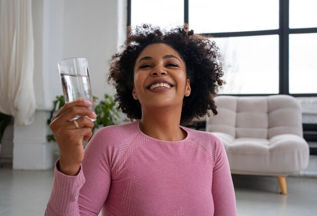 Coup moyen femme en forme buvant de l'eau