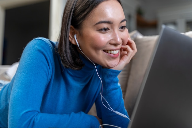 Coup moyen femme heureuse avec ordinateur portable à la maison