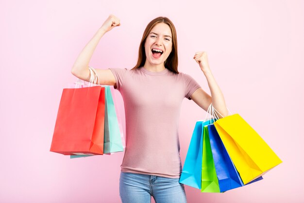 Coup moyen de femme heureuse tenant des sacs à provisions