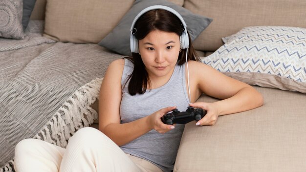 Coup moyen femme jouant au jeu vidéo