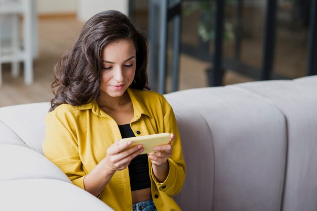 Coup moyen femme jouant au téléphone