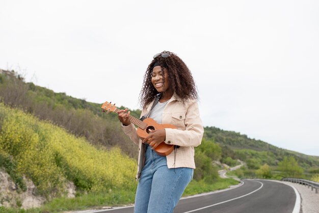 Coup moyen femme jouant de la guitare