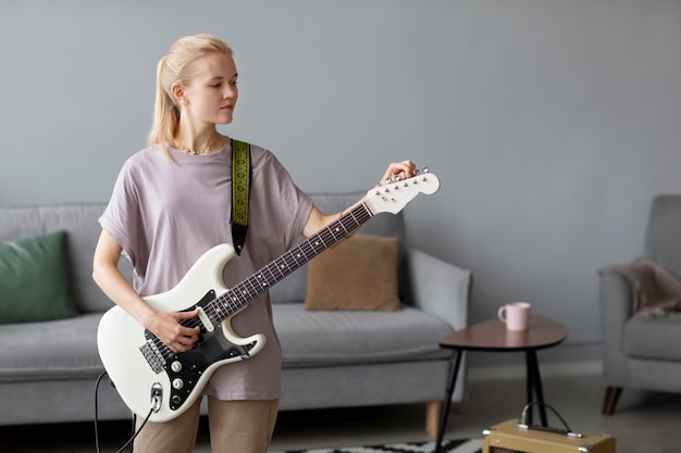 Coup moyen femme jouant de la guitare