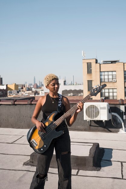 Coup moyen femme jouant de la guitare