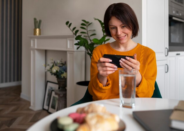 Coup moyen femme jouant avec son téléphone