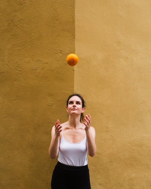 Coup moyen femme lançant une orange