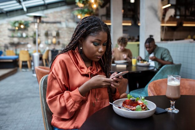 Coup moyen femme lisant dans un café