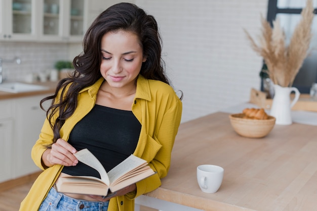 Coup moyen femme lisant dans la cuisine